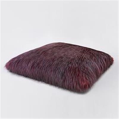 A square pillow with purple fur on top of it.