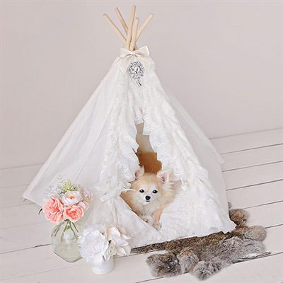A dog inside of a teepee with flowers