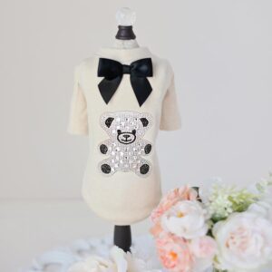 A white shirt with a black bow and a teddy bear on it.
