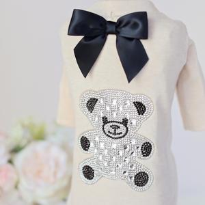 A white shirt with a black bow and a bear on it